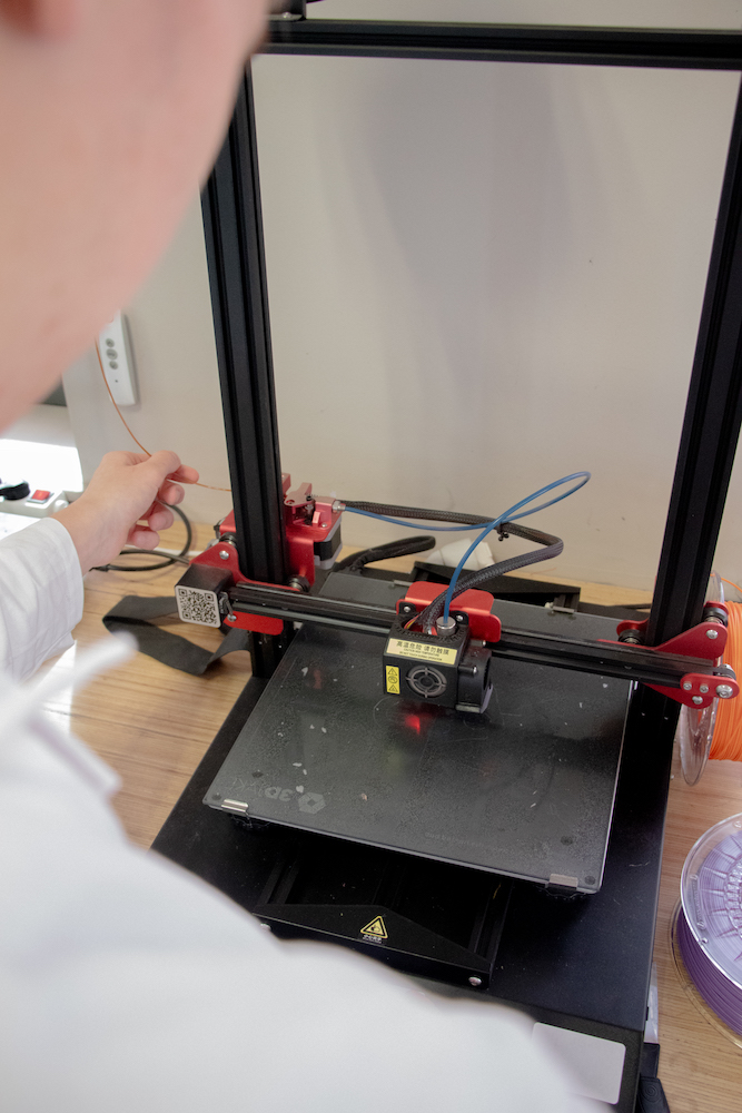 Impression 3d plastique - Employé de Normandy Ecospace préparant une imprimante 3D pour une prochaine session d'impression.